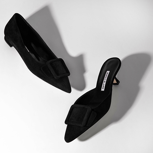 Image of two women's black shoes, a flat pump and a low heel mule.