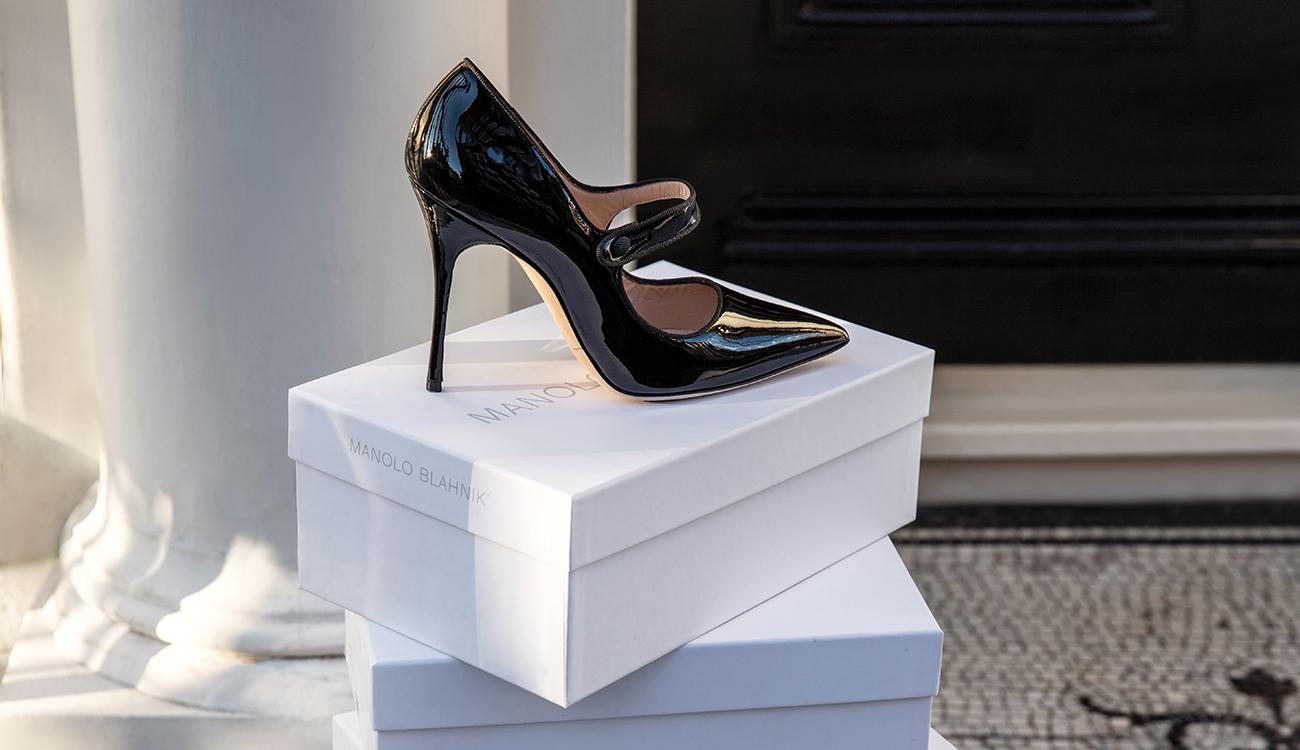 Image of black patent Mary Jane shoe on top of a stack of Manolo Blahnik white boxes 